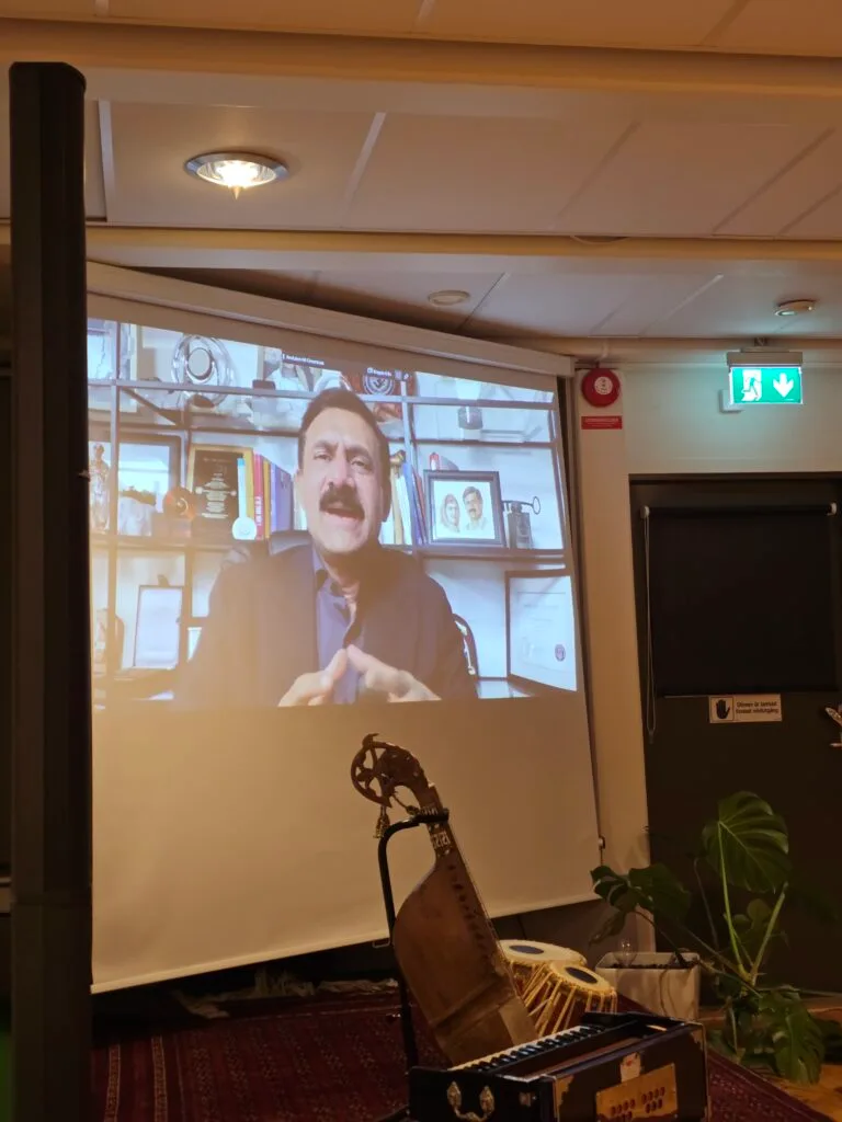 Pashto Music Institute Launches in Malmö, Sweden, Heralding a New Era of Musical Heritage Preservation A screen showing Ziauddin Yousafzai delivering a video message during the Pashto Music Institute's launch in Malmö, Sweden. Traditional Pashto instruments like the rubab and tabla are displayed in front of the screen.